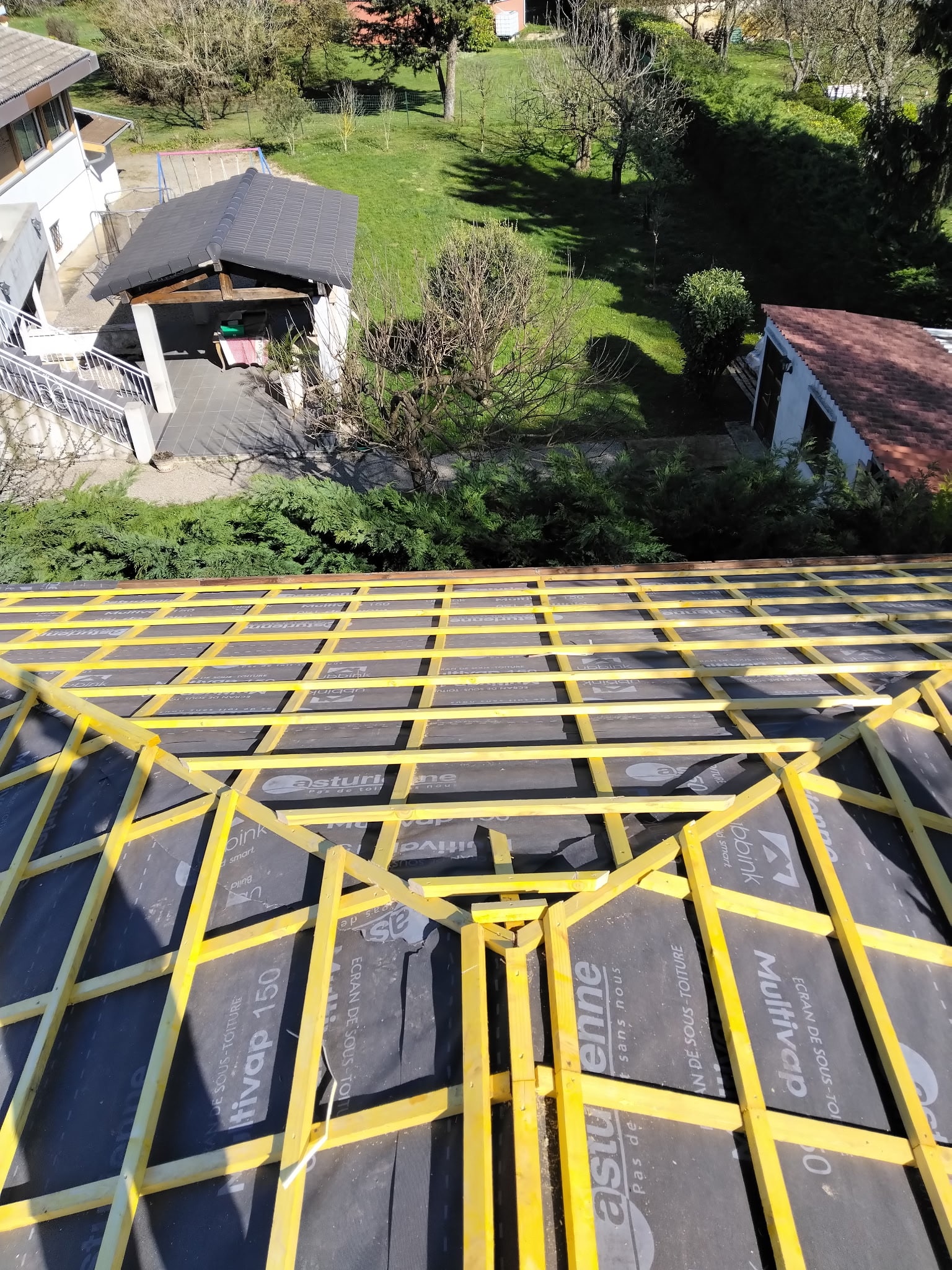 Rénovation Toiture : Charpente Bois et Écran Multivap 150 Charpente bois jaune sur membrane Multivap 150, écran de sous-toiture Asturienne en cours de rénovation.